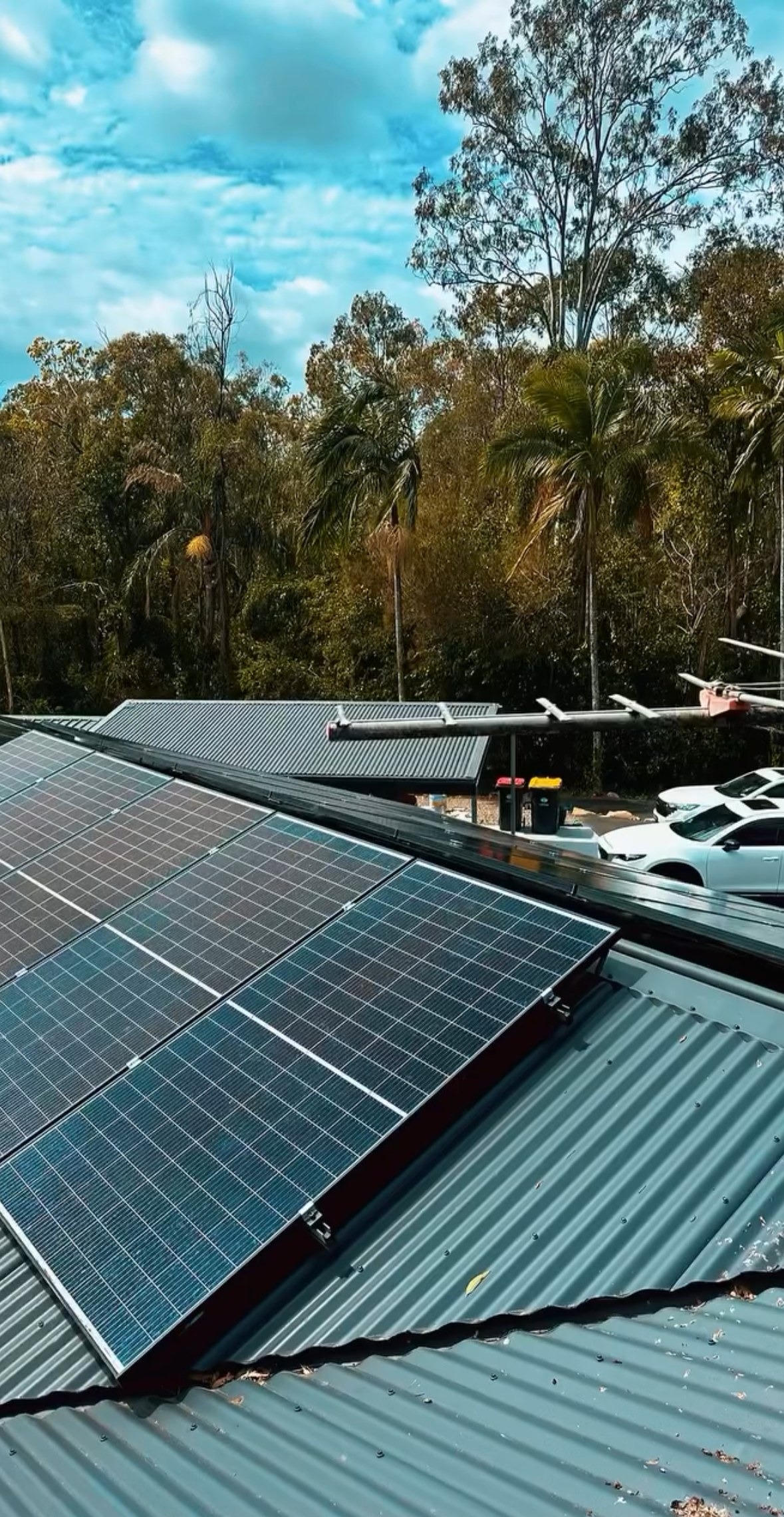 Solar panels on a metal roof at a property in a leafy local setting